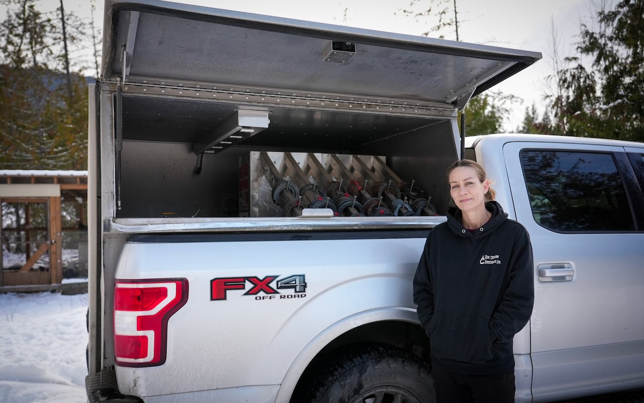 Woman standing in front of a truck filled with horseshoes 