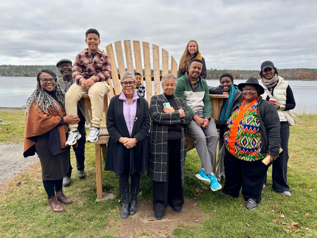 Louise Delisle, centre, Amnesty International workers and others pose in front of a giant adirondack chair in October 2025.