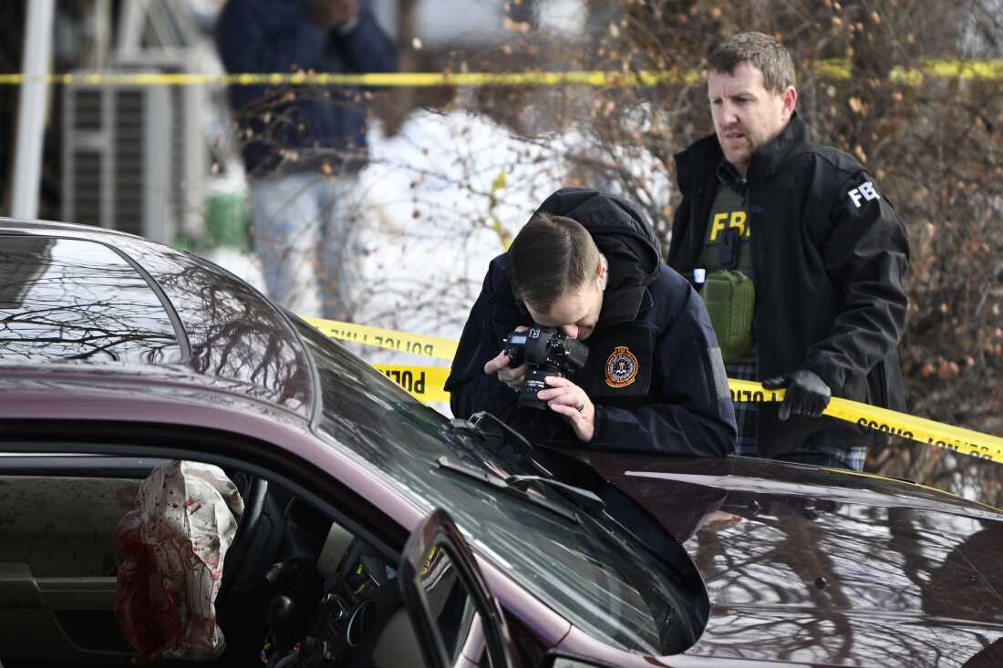 Members of law enforcement photograph a vehicle suspected to be involved in a shooting by an ICE agent during federal law enforcement operations on Wednesday in Minneapolis.