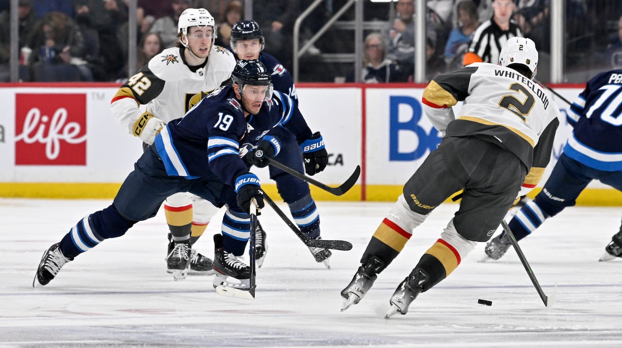 Two hockey players battle for the puck in open ice.