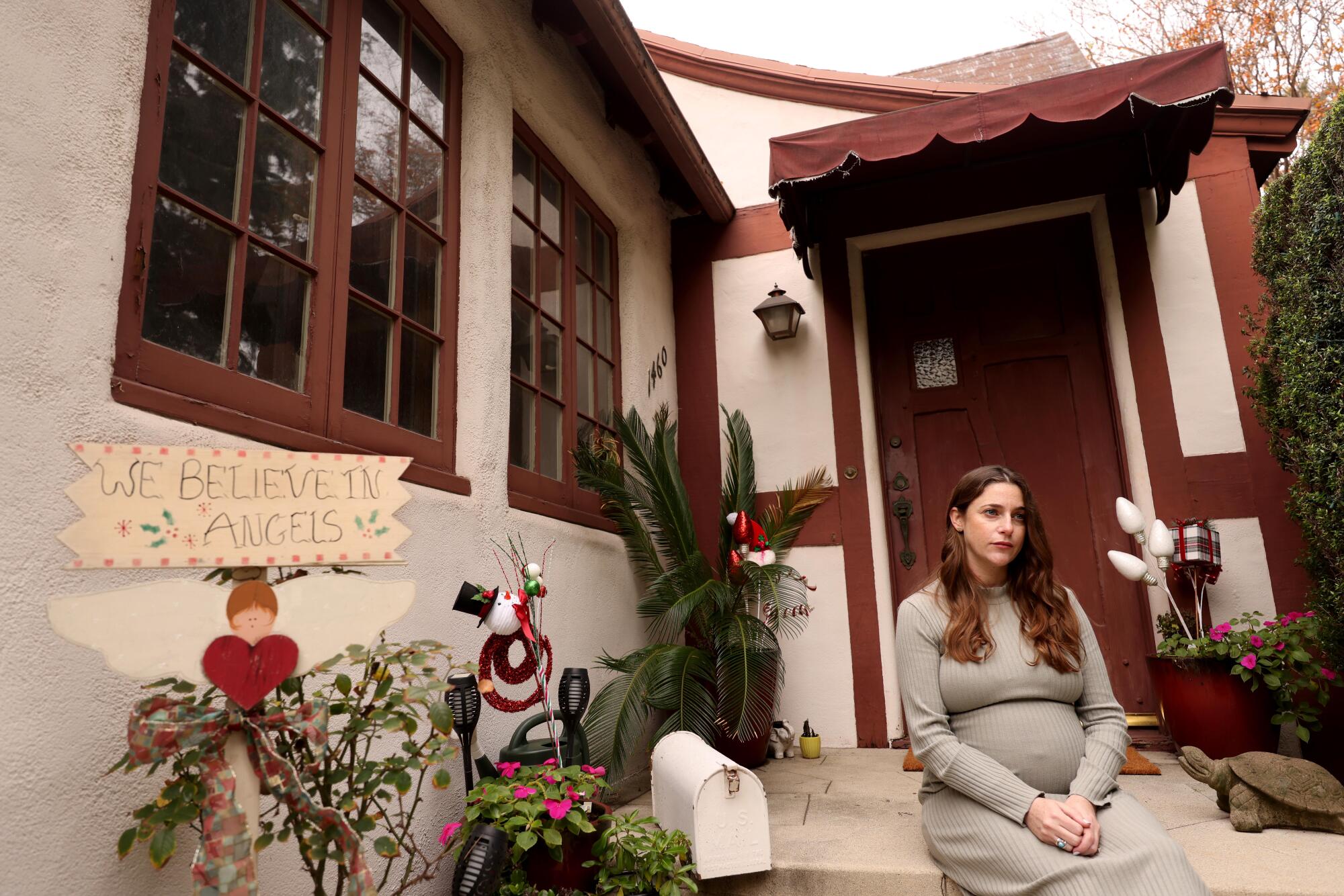 a woman sits on the porch of a home