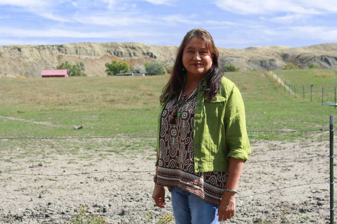 LeeAnn Bruised Head stands before the hillside near her childhood home on the Crow Indian Reservation, where she grew up riding horses.