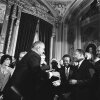 President Lyndon B. Johnson extends a hand to shake hands with Martin Luther King Jr. while others watch at the U.S. Capitol in 1965.