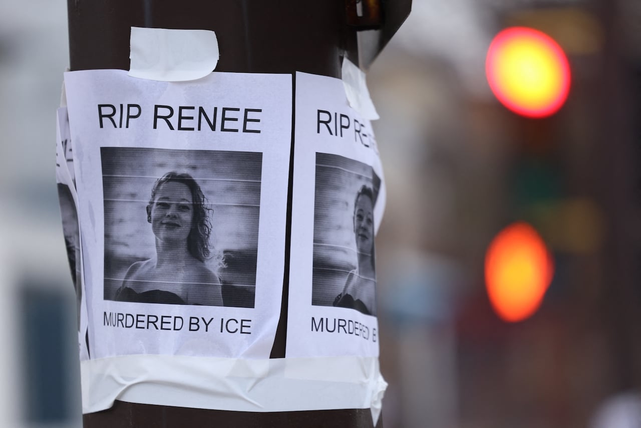 A poster taped to a sighnpost that says RIP Renee, and shows a smiling woman
