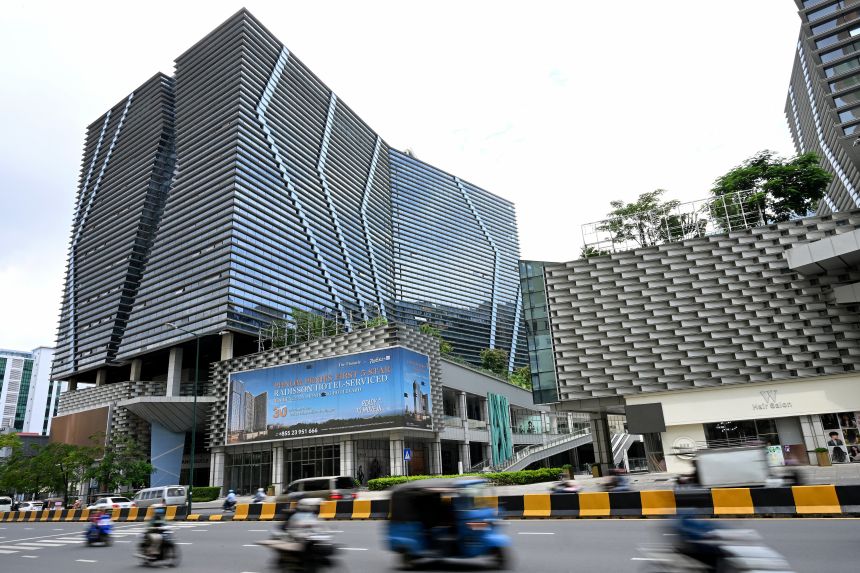 Vehicles drive past the Prince International Plaza in Phnom Penh, Cambodia, on October 15, 2025.