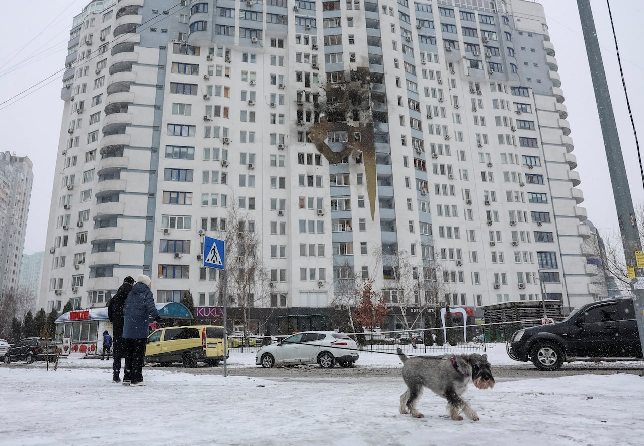  Residents stand at the site of the apartment building hit by a Russian drone strike, amid Russia's attack on Ukraine, in Kyiv, Ukraine January 9, 2026. 