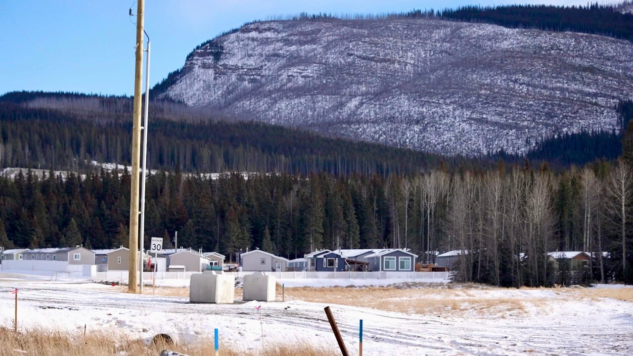 A mountain range towering over several houses.