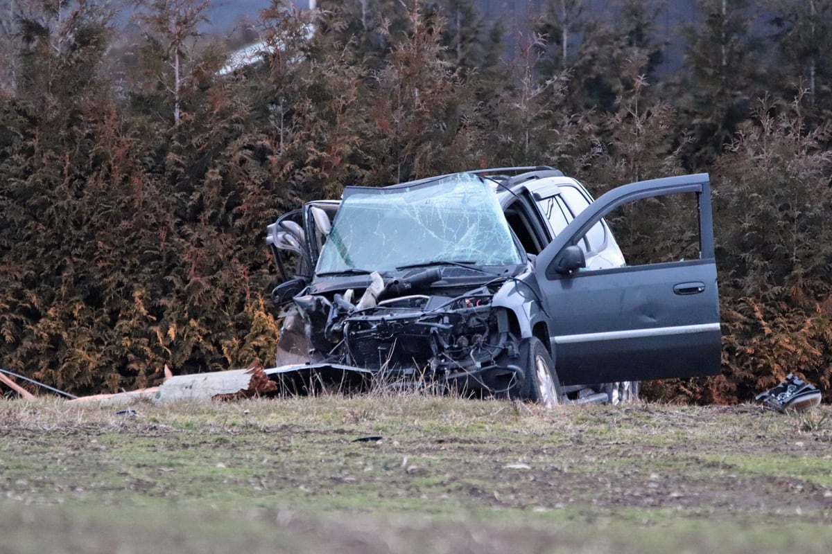 A crashed car is pictured on grass. 