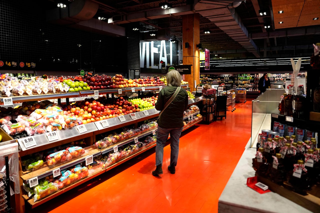 A customer looks for produce at a grocery store in Ottawa, on Wednesday, April 2, 2025. Experts say many shoppers are moving away from traditional grocery stores like this one in favour of discount grocery stores amid rising food prices.