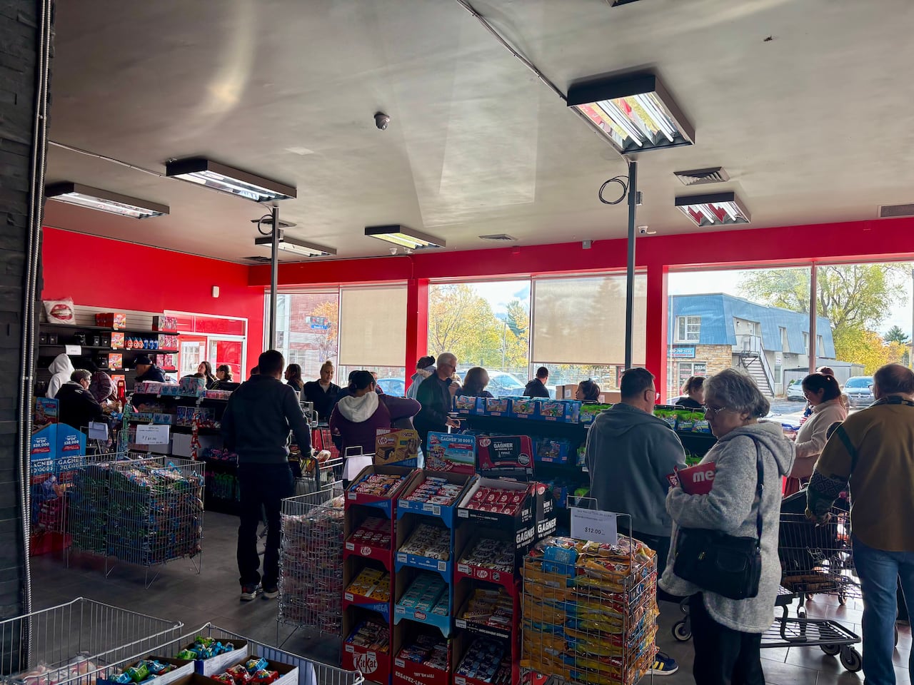 Shoppers wait in line inside Liquidation Marie grocery store in Longueuil, Quebec. The store is gaining in popularity among other discount grocery chains amid rising food prices across Canada.