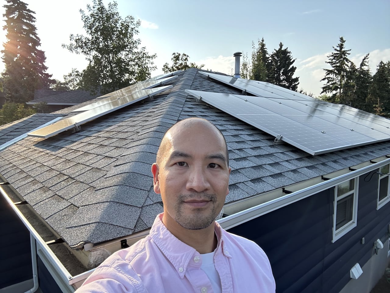 Man in front of a roof with solar panels