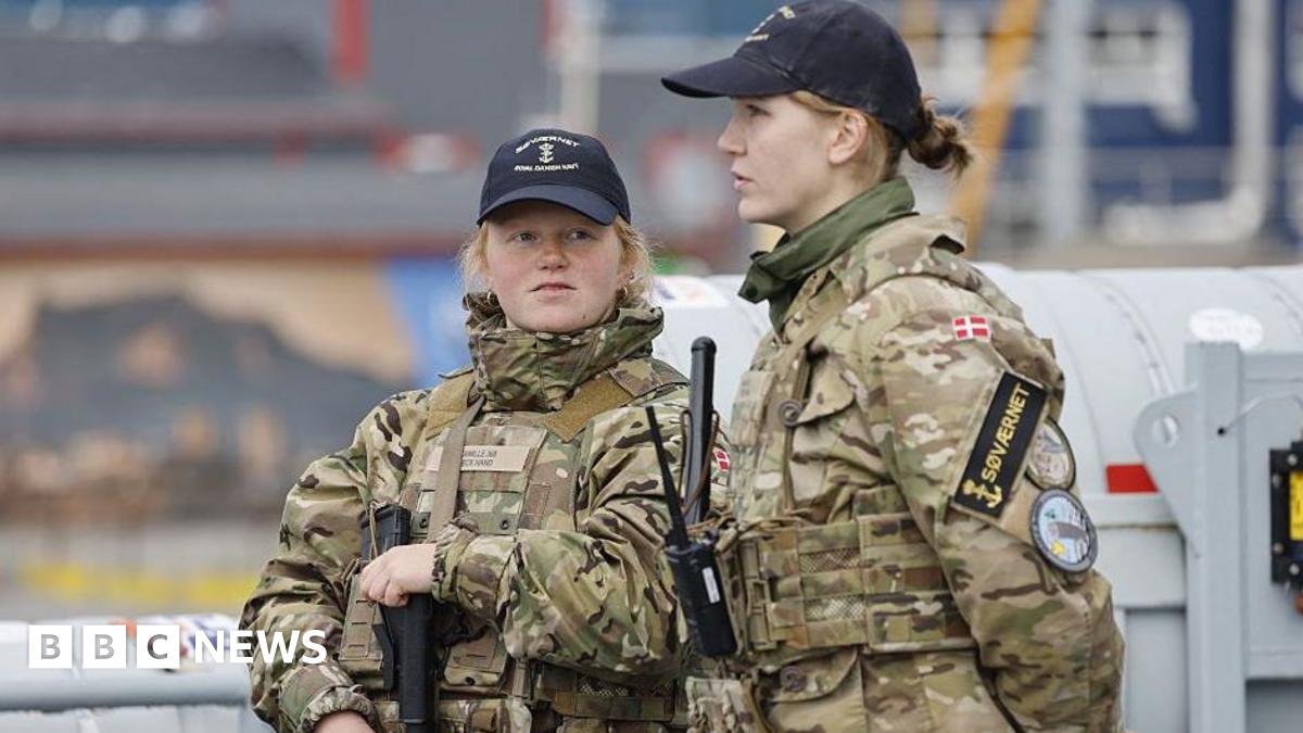 Two female members of the Royal Danish Navy stand guard on a warship in Nuuk, Greenland.