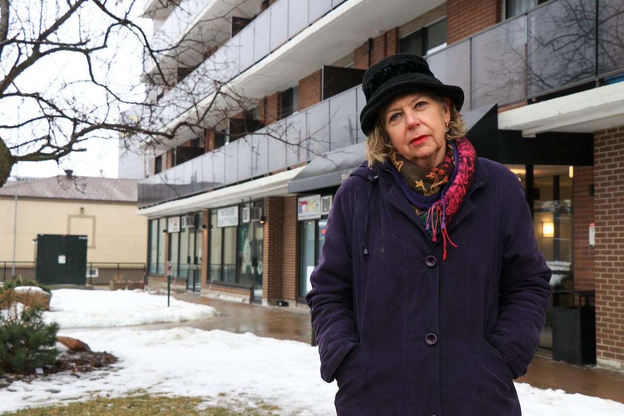 woman stands in front of building