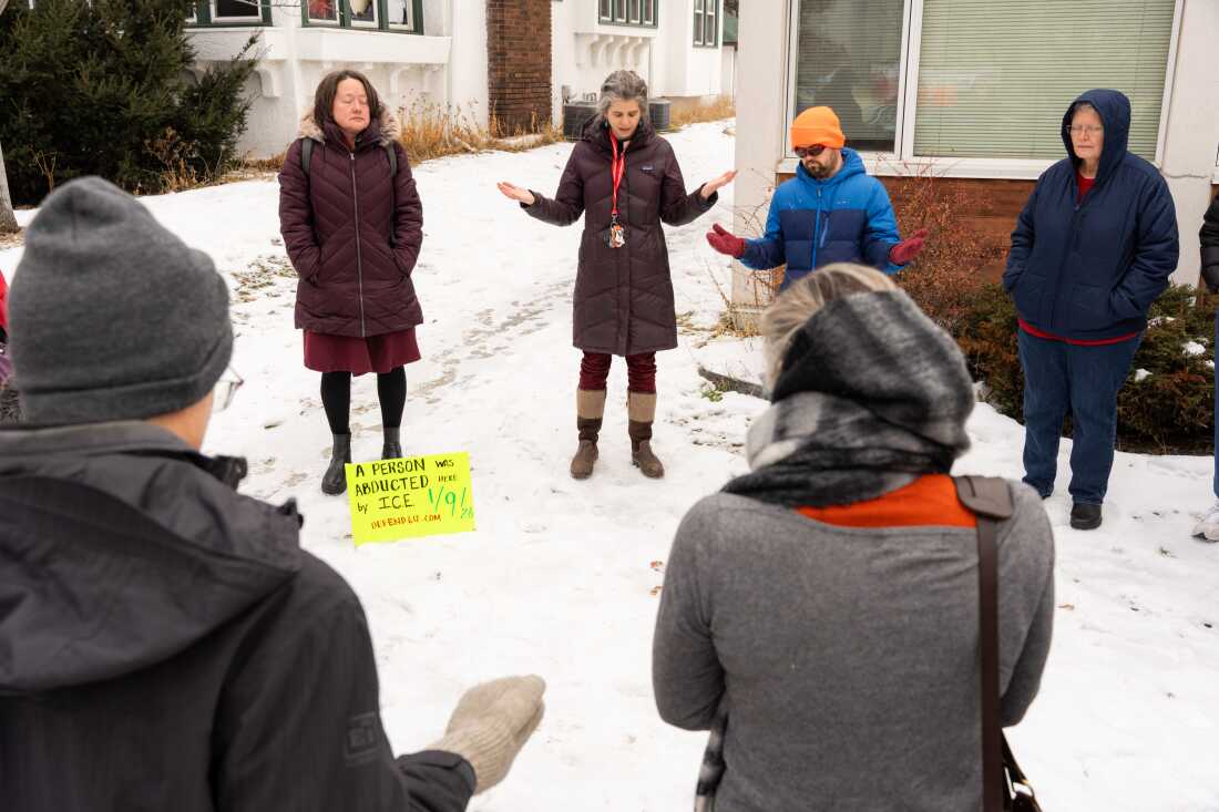 Parishioners of Our Saviour's Lutheran Church gather outside to pray together after placing a sign marking the sight where a community member was abducted by ICE two day prior in Minneapolis on Sunday.