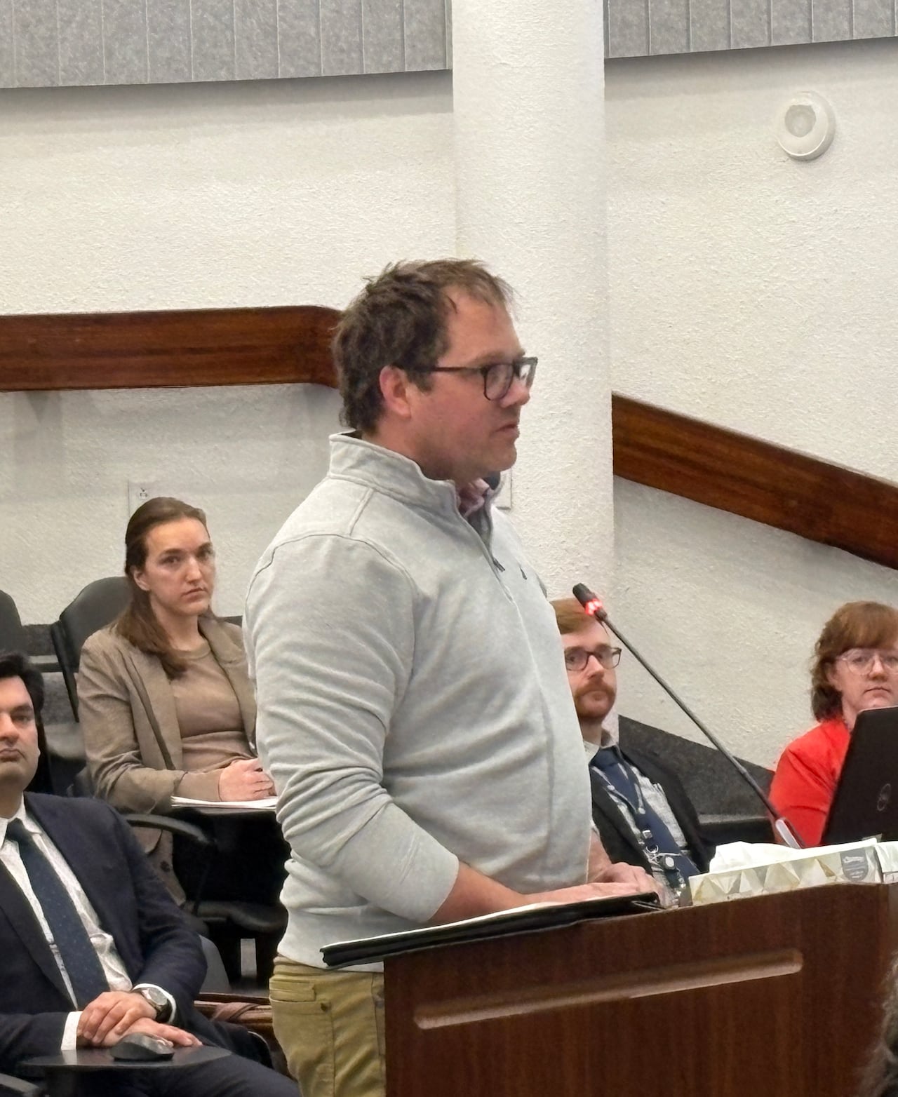 Man standing at a podium and speaking into a mic. 