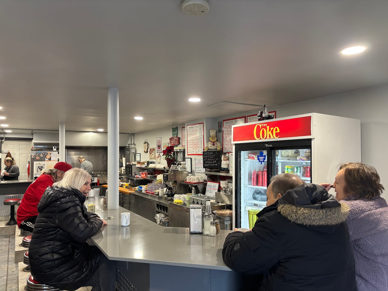 four regular customers sitting at the bar laughing together