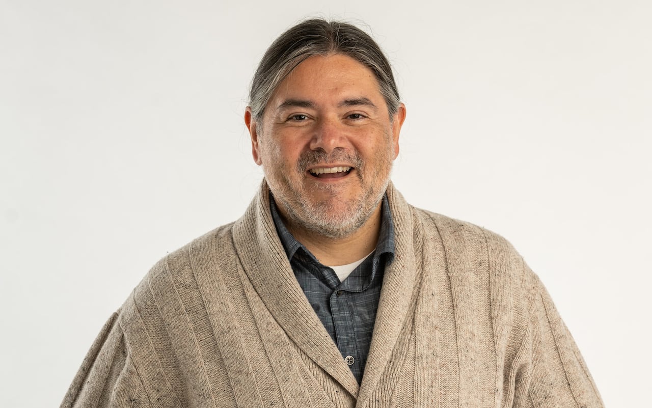 Man wearing sweater smiling.