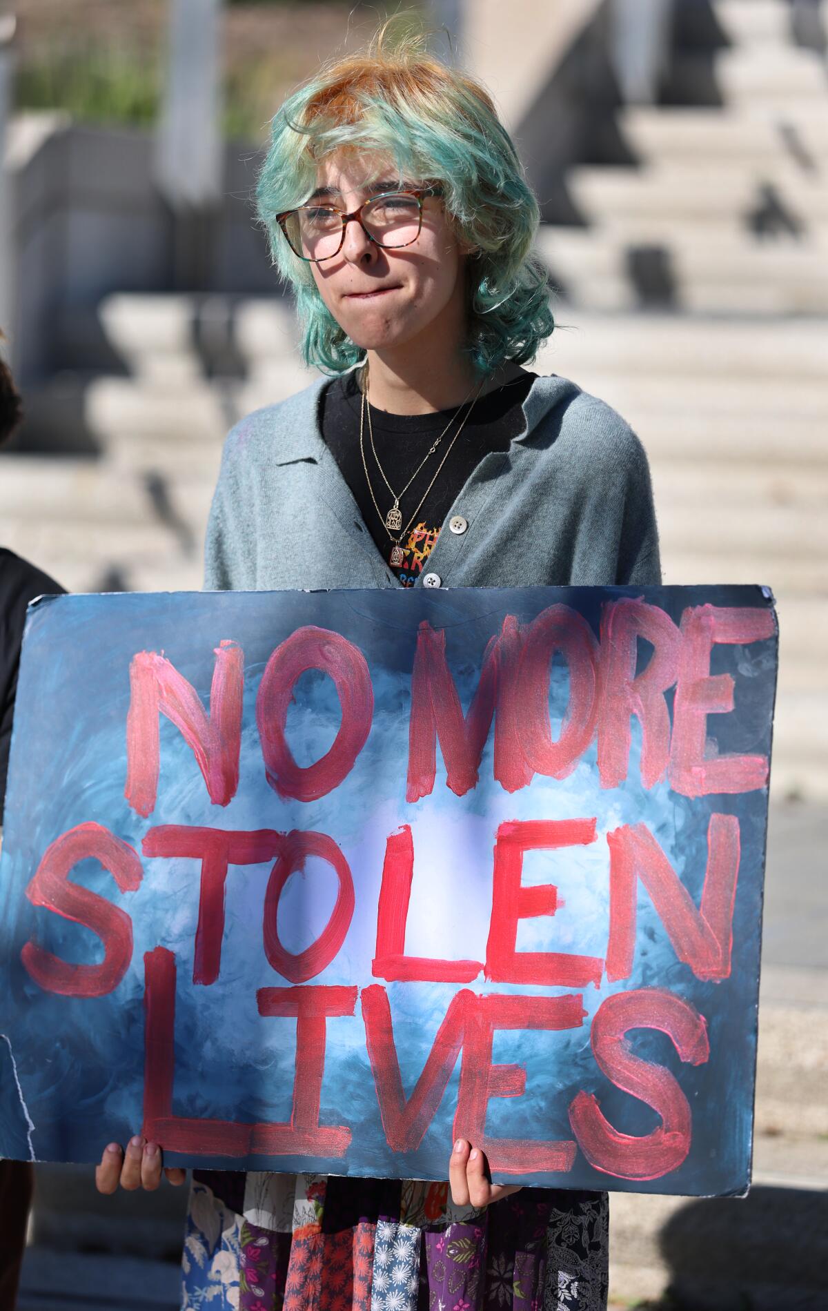 Rue El Amar holding a sign during a news conference