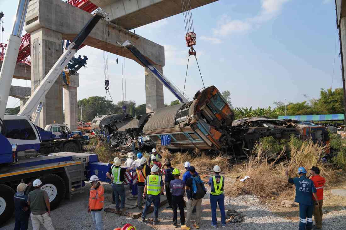 Rescuers try to lift the wreckage after a construction crane fell into a passenger train in Nakhon Ratchasima province, Thailand, Wednesday, Jan.14, 2026.
