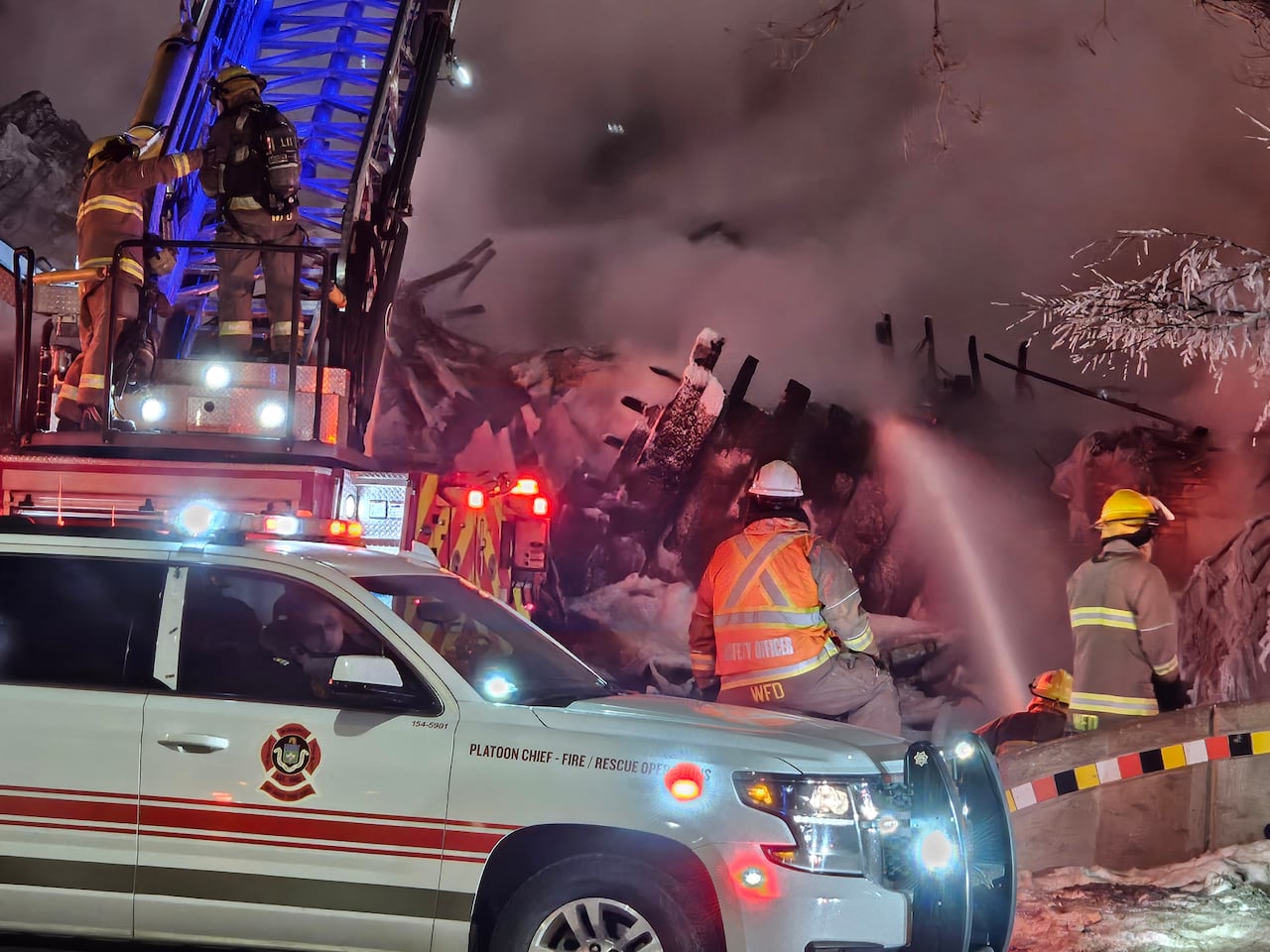 Firefighters hose down the rubble of a collapsed building after a fire.