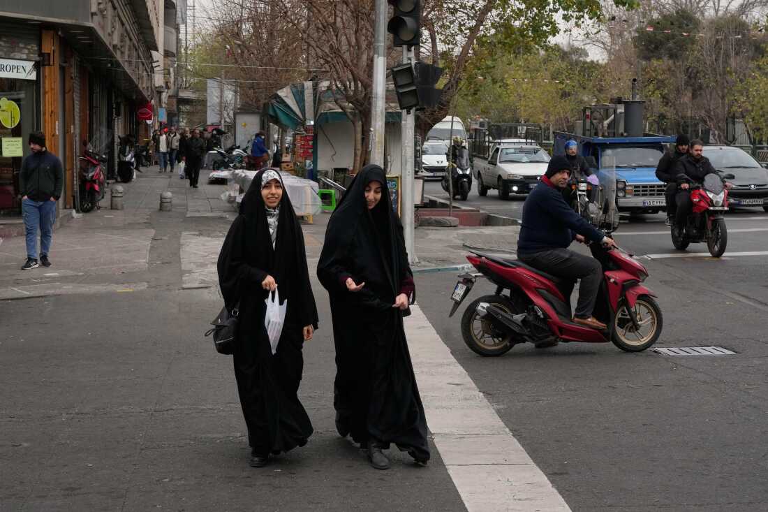 Women cross an intersection in downtown Tehran, Iran, Thursday.