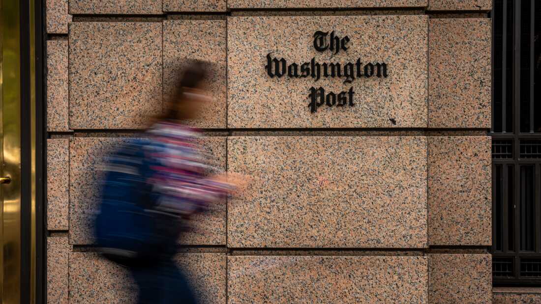 A blurred person walks past the The Washington Post Building at One Franklin Square Building in Washington, D.C. 
