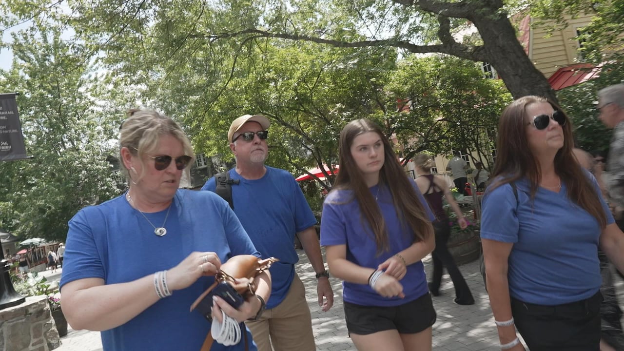 Four people walk beside one another.