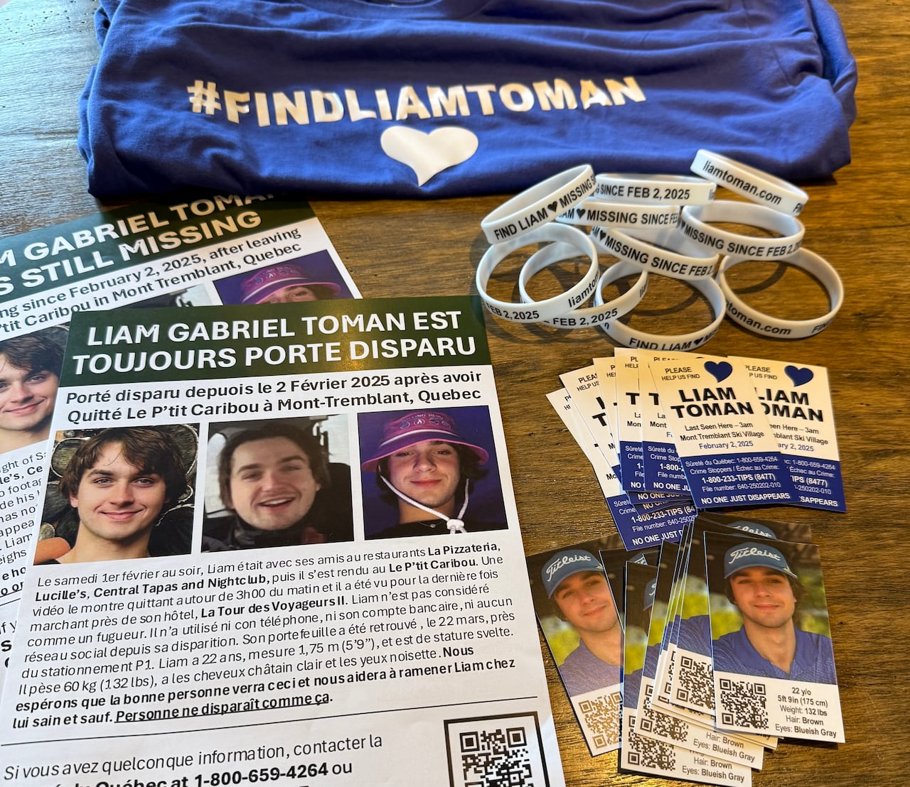 Pamphlets with the photo of Liam Toman are strewn across a wooden table.