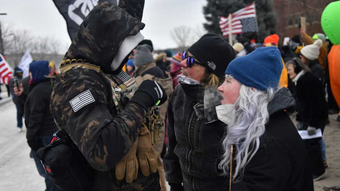 Protesters (R) are confronted by an ICE supporter during a demonstration outside the Bishop Whipple Federal Building in Minneapolis, Minn.