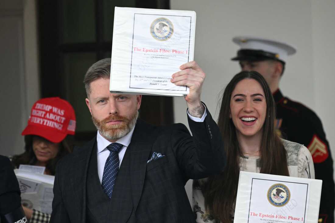 Political influencer Rogan O'Handley, known online as DC Draino, center, next to influencers Jessica Reed Kraus on the left and Chaya Raichik, right, carry binders bearing the seal of the U.S. Justice Department reading "The Epstein Files: Phase 1" as they walk out of the the White House in February 2025. The administration mostly released old materials to the influencers, leading to disappointment and strains within Trump's coalition.