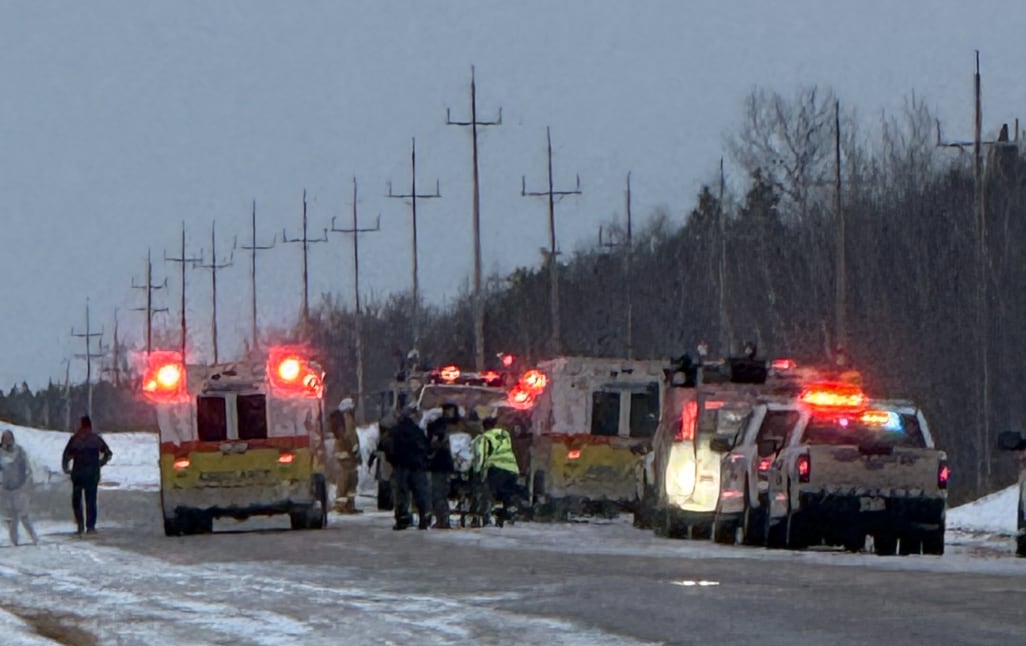 Emergency crews lineup on a icy highway.