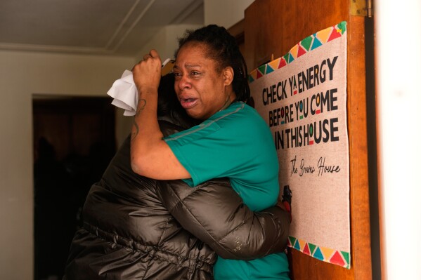 ADDS IDENTIFICATION: Teyana Gibson Brown, right, wife of Garrison Gibson, reacts after federal immigration officers arrested Garrison Gibson, Sunday, Jan. 11, 2026, in Minneapolis. (AP Photo/John Locher)