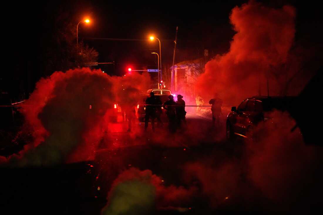 Tear gas surrounds federal law enforcement officers as they leave a scene after a shooting on Wednesday, Jan. 14, 2026, in Minneapolis.