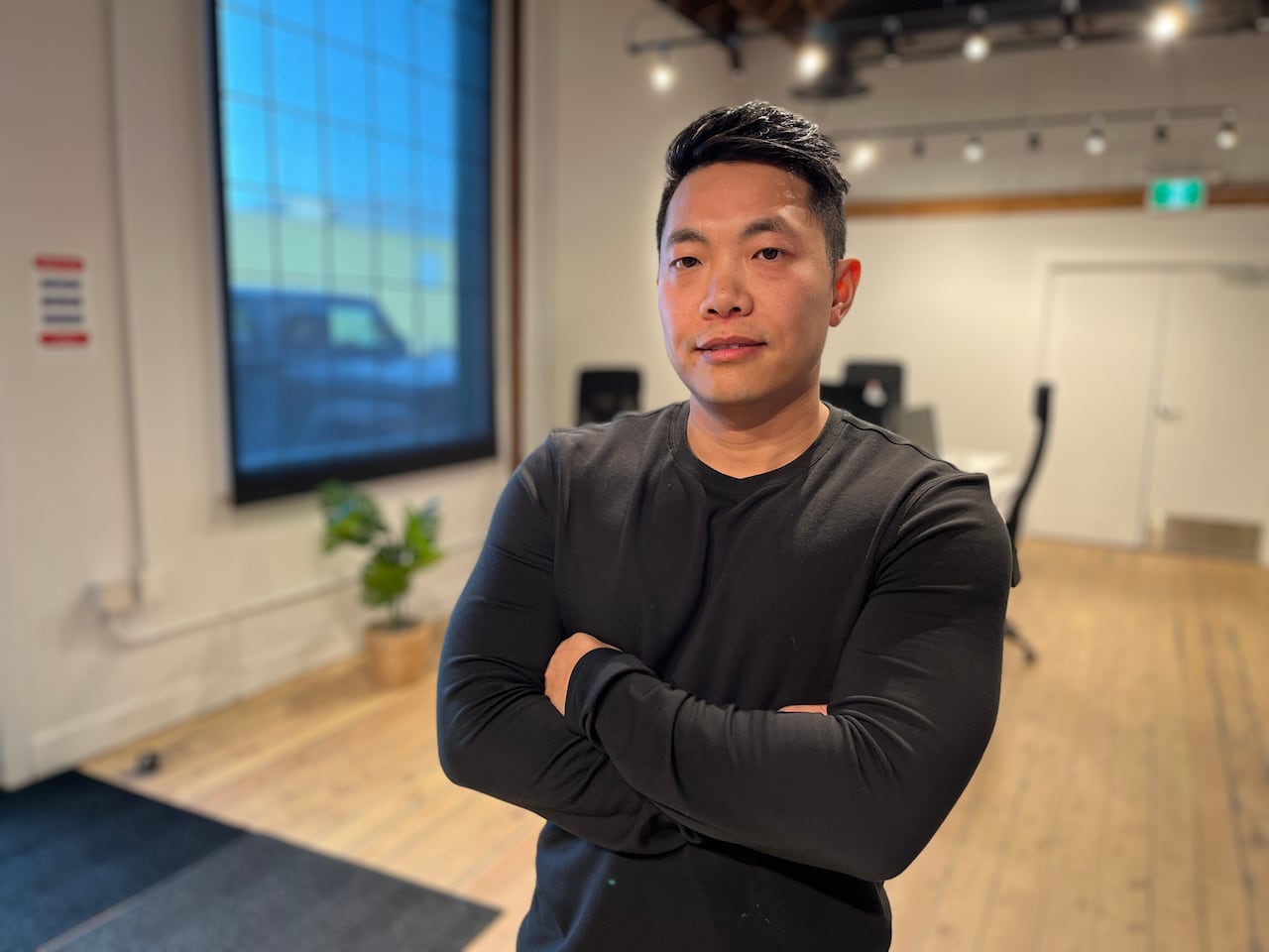 A man in a long-sleeved black t-shirt is pictured in a co-working space in Calgary.