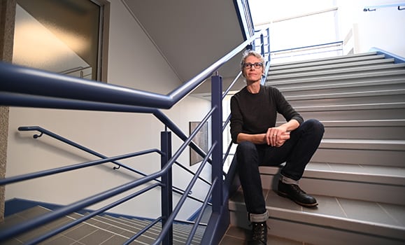 A woman sits on a staircase. 