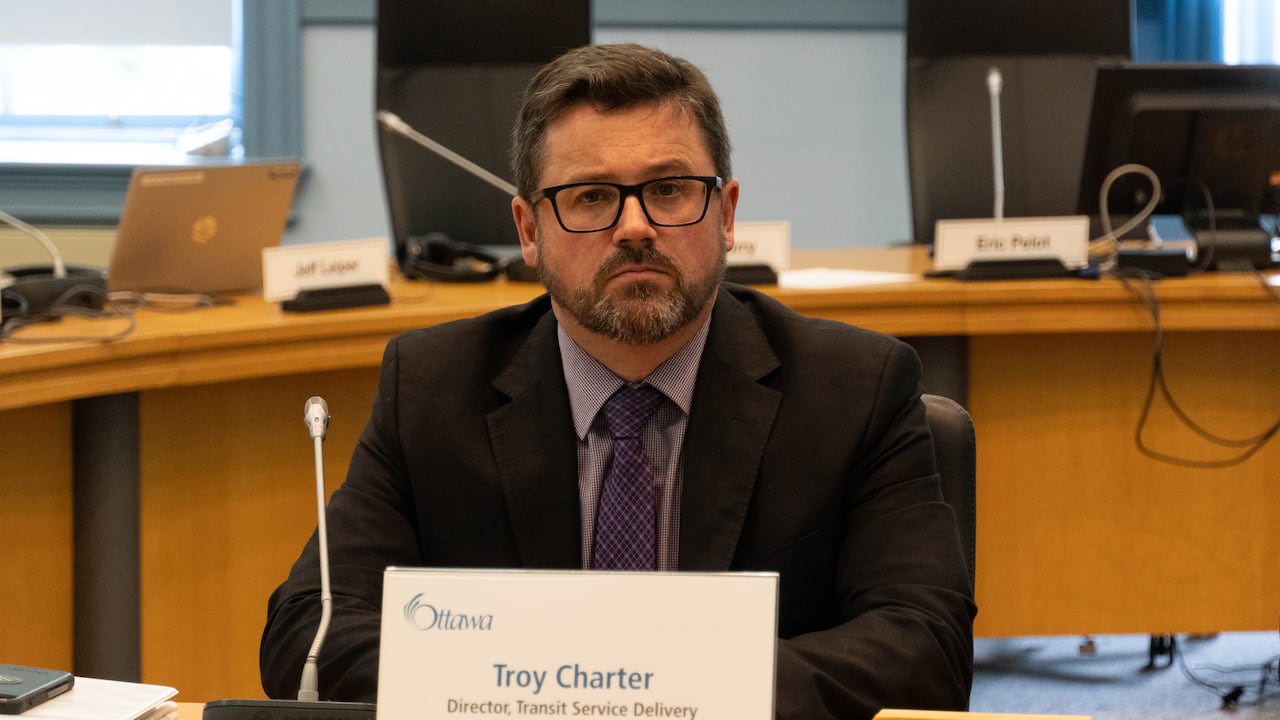 A man sits behind a name tag.