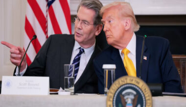 Donald Trump and Bessent in discussion at a public event, highlighting key political and business interactions