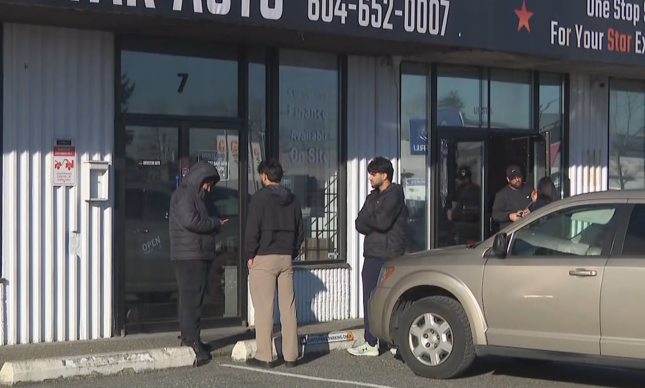 People are seen outside a suburban business.