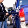 A man pumps gas into his pickup at a gas station.
