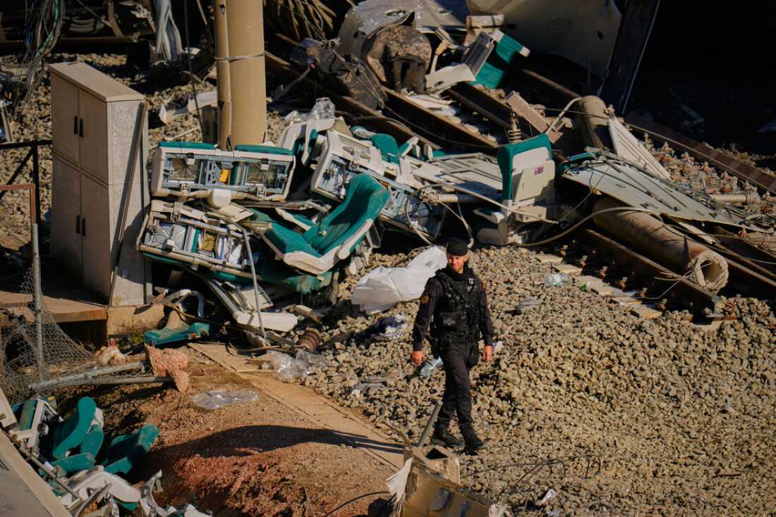 Guardia Civil officers collect evidence Tuesday next to the wreckage of train cars involved in a collision in Adamuz in southern Spain.