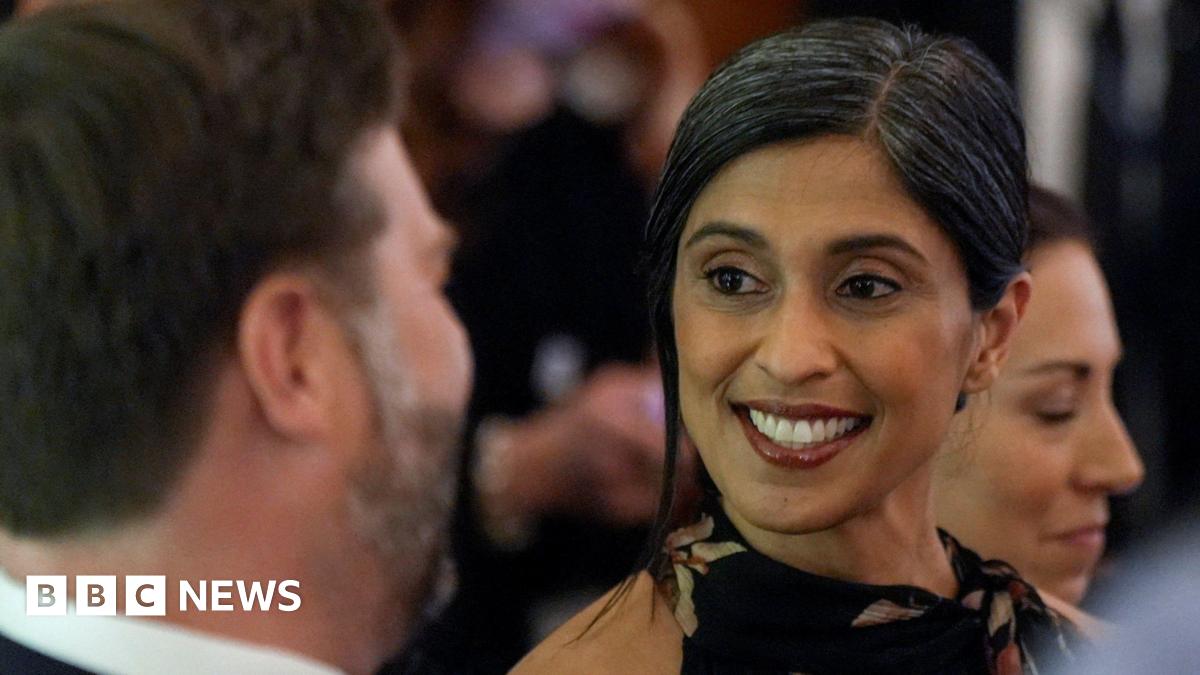Donald Trump and Keir Starmer sit in a formal drawing room setting  on arm chairs with US and UK  flags behind them. Both have serious expressions and are looking out and not at each other.