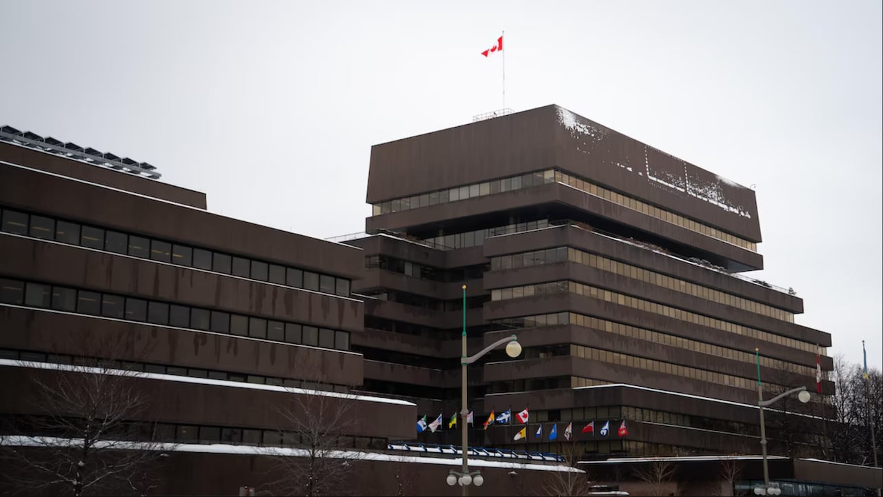 A brown building with a Canadian flag on top.