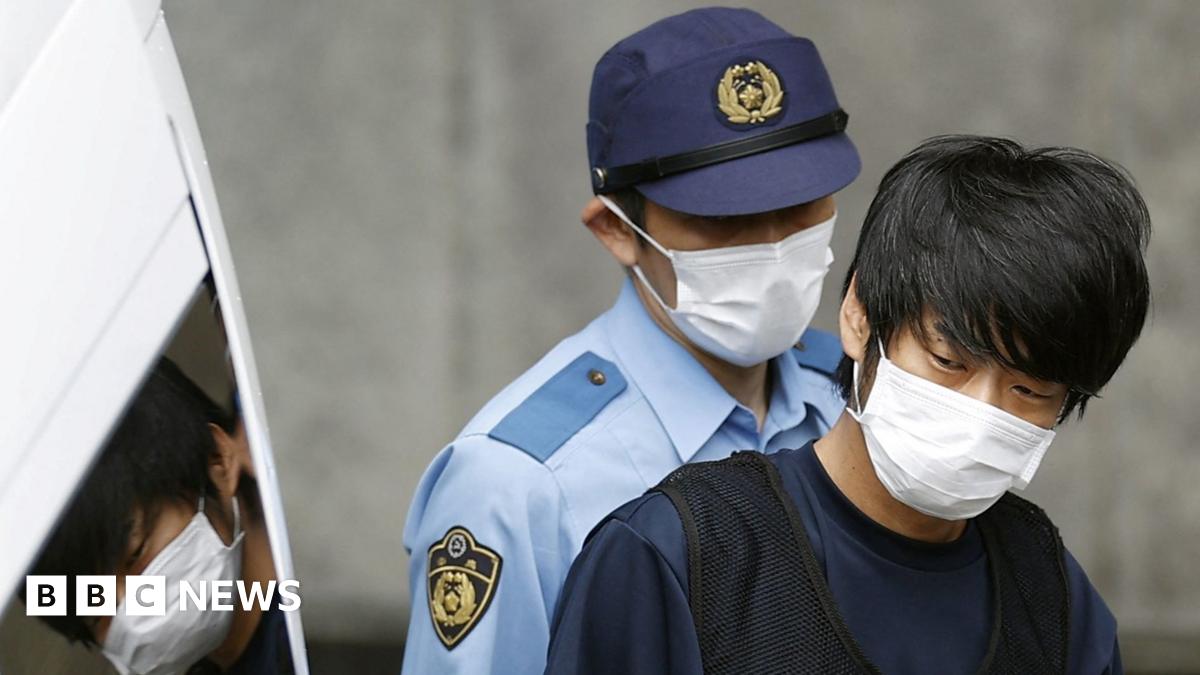 Tetsuya Yamagami, suspected of killing former Japanese Prime Minister Shinzo Abe, is escorted by a police officer as he is taken to prosecutors, at a police station in Nara in 2022.