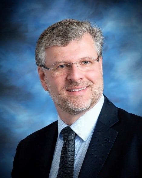 A man against a blue background.