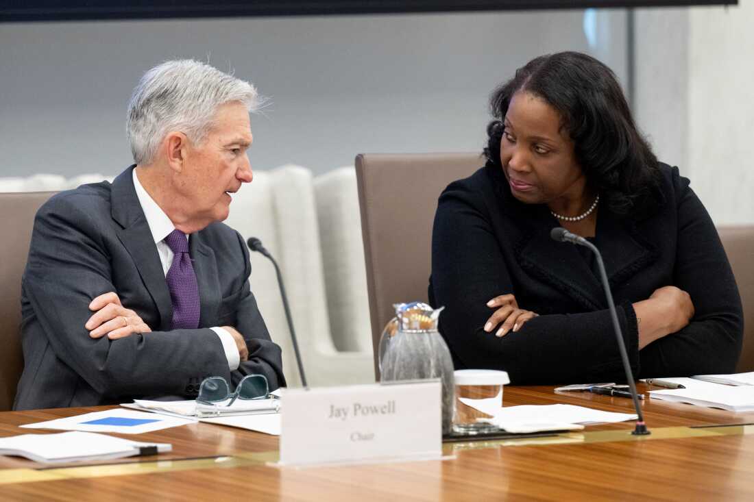 Fed Chair Jerome Powell speaks with Lisa Cook, a member of the Board of Governors of the Federal Reserve, during a meeting in Washington on June 25.