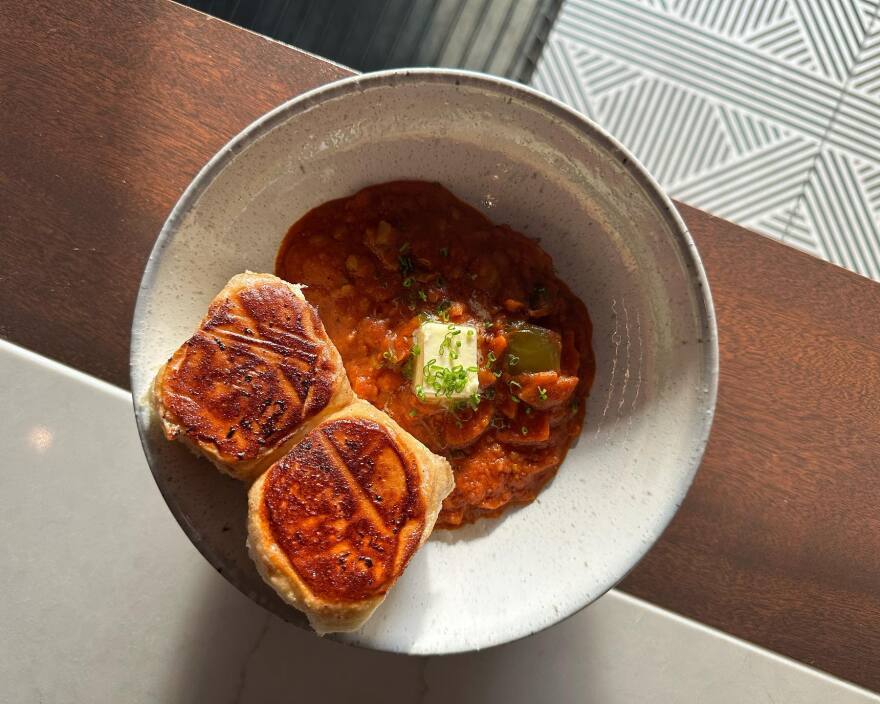 A bowl of pav phaji, tomato-based Indian curry with bread.
