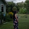 A woman poses for a portrait outside her home, Saturday, July 19, 2025, in Tampa. Her family are discussing emergency plans if she or her husband were to be detained, and are looking to move to another state where the police presence is less felt. (Lexi Parra for NPR)