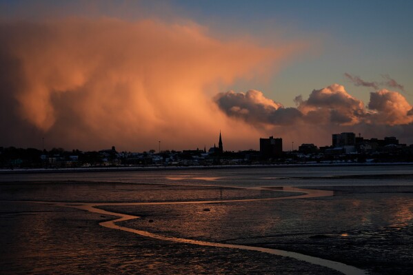 Storm clouds that had brought brief snow flurries begin to clear, Tuesday, Jan. 20, 2026, over Portland, Maine. (AP Photo/Robert F. Bukaty)