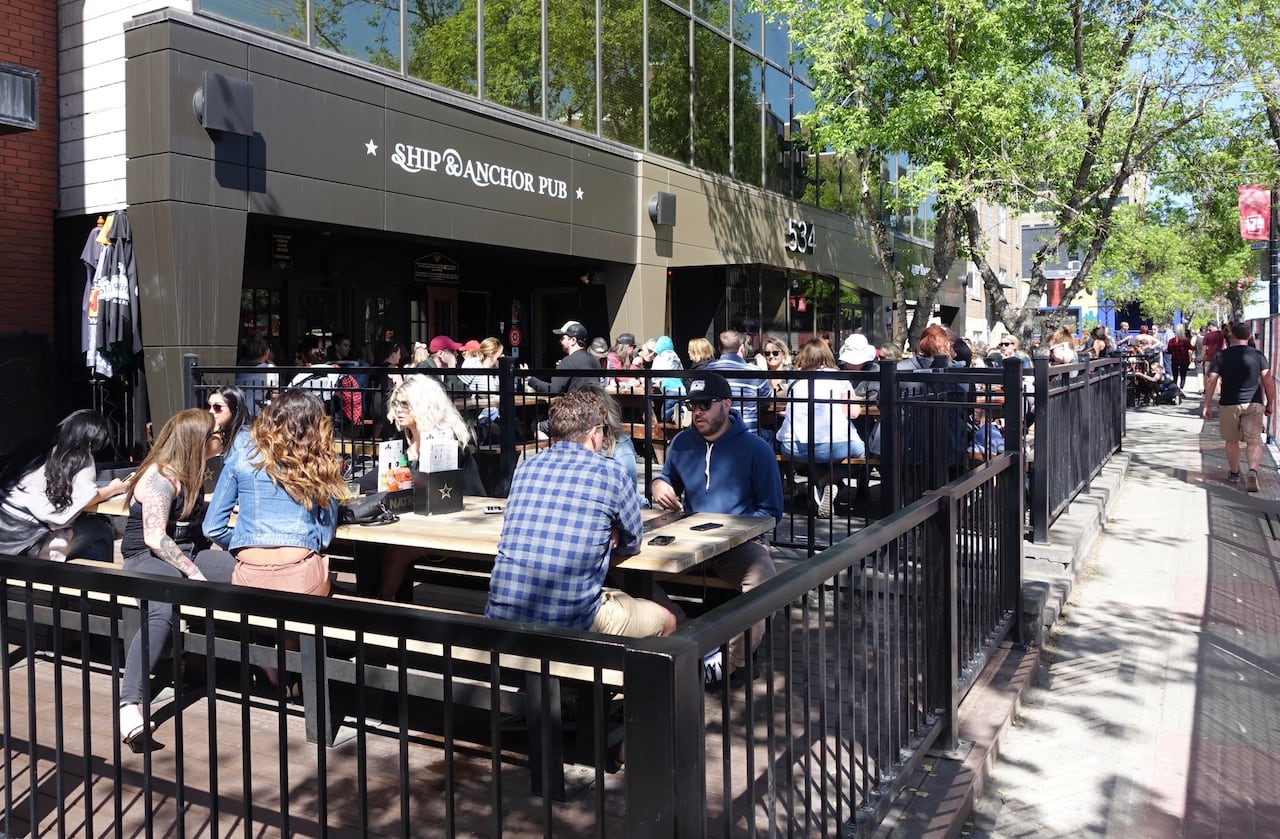 People sit on picnic tables outside.