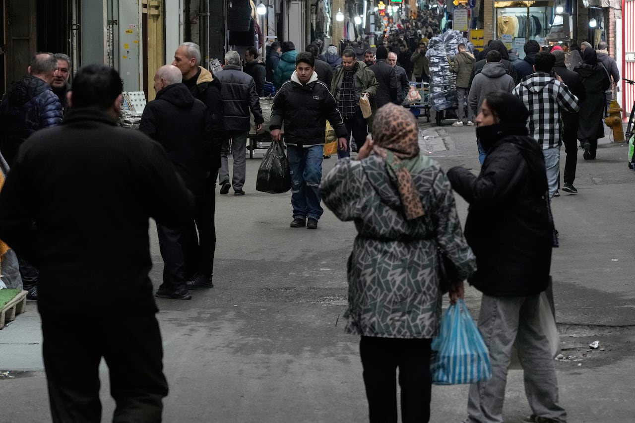 People walk along a busy street.
